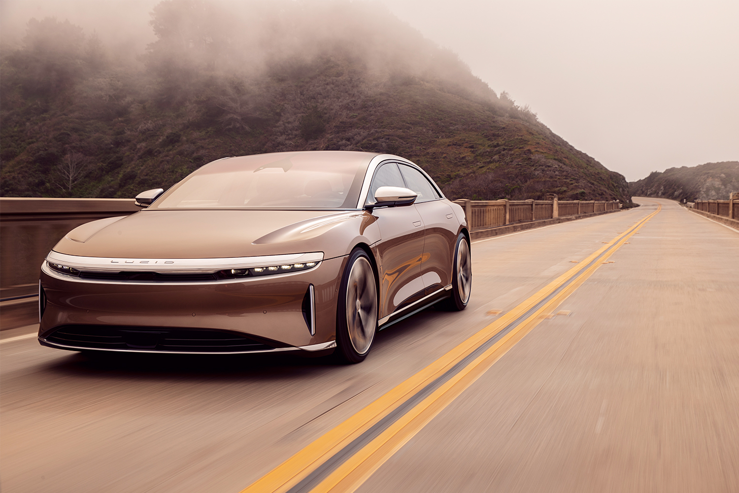 The Lucid Air electric car driving across a bridge in foggy conditions. The Lucid Air Dream Edition Range got official EPA range in September 2021.