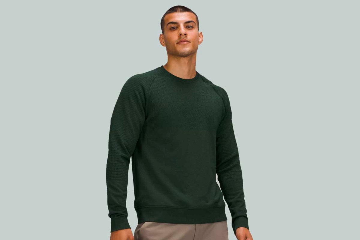 A man wearing the Engineered Warmth Long Sleeve Crew from Lululemon in Rainforest Green