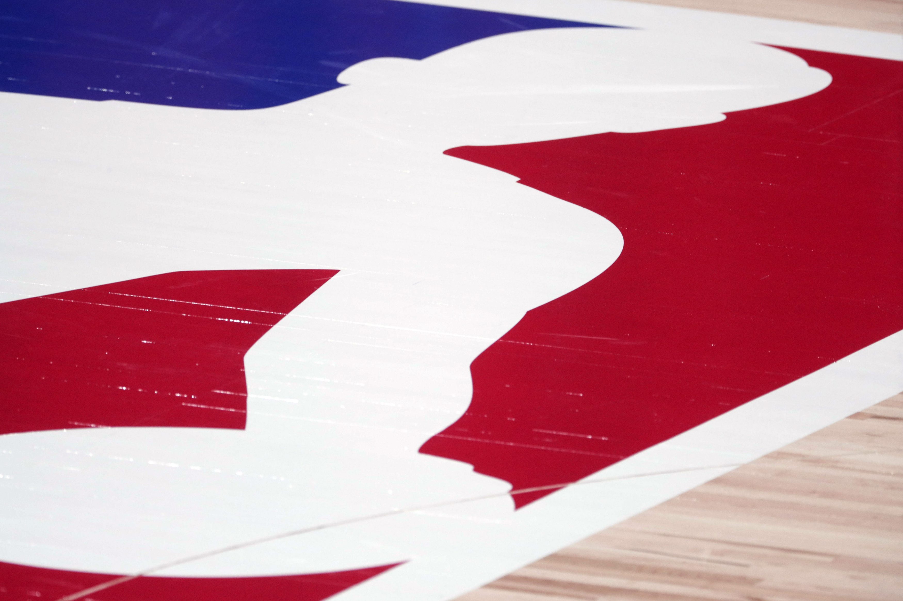 Closeup of the NBA logo on court before a playoff game. Unvaccinated players now face additional hurdles in certain cities if they want to play (including not being able to play in certain arenas)