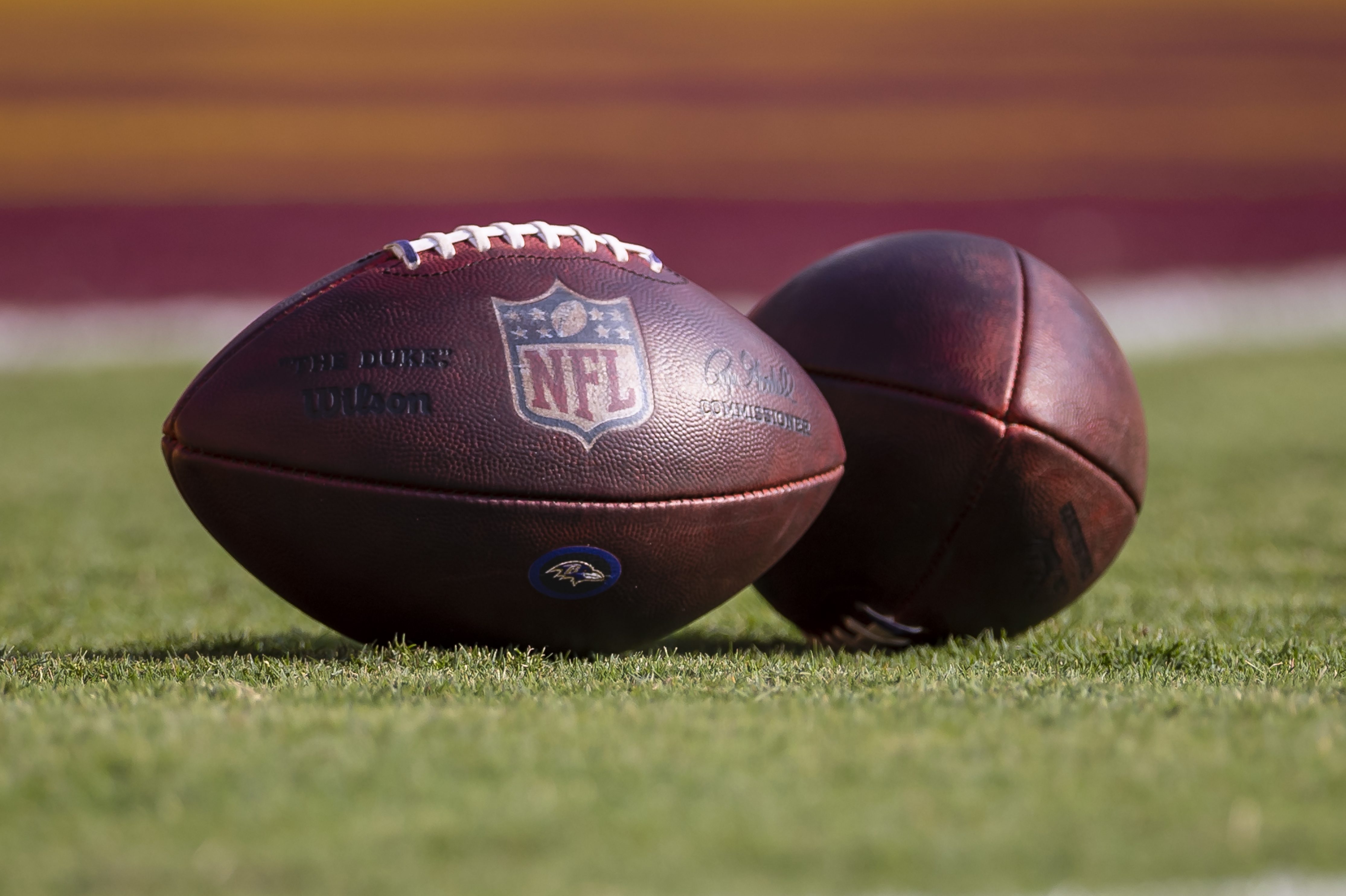 Two NFL footballs on the field before a 2021 preseason game