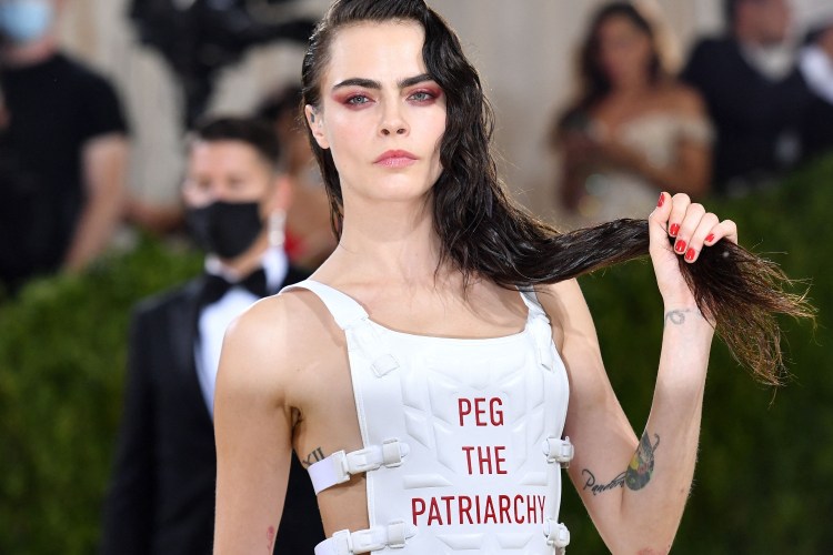 Cara Delevingne wears a white vest with the words "Peg the Patriarchy" at the 2021 Met Gala.