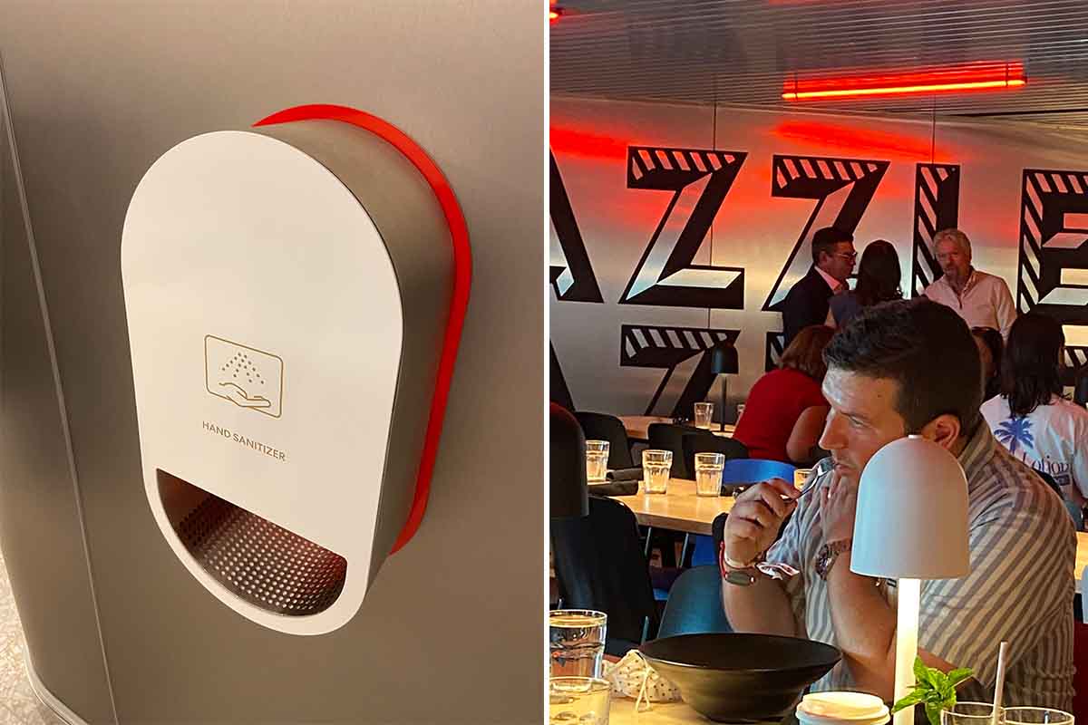 hand sanitizing station on left, Richard Branson in background at Razzle Dazzle restaurant on right on board the Scarlet Lady