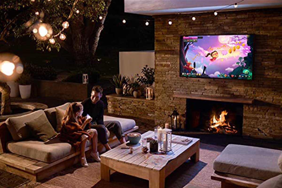 A father and daughter watching a Samsung Terrace TV outside