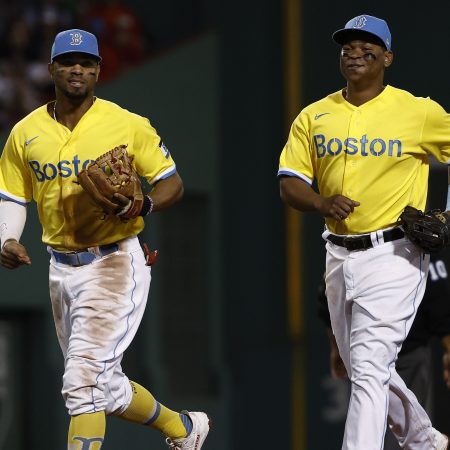 Rafael Devers and Xander Bogaerts of the Boston Red Sox share a laugh. The team is continuing to wear their yellow uniforms during a recent win streak.