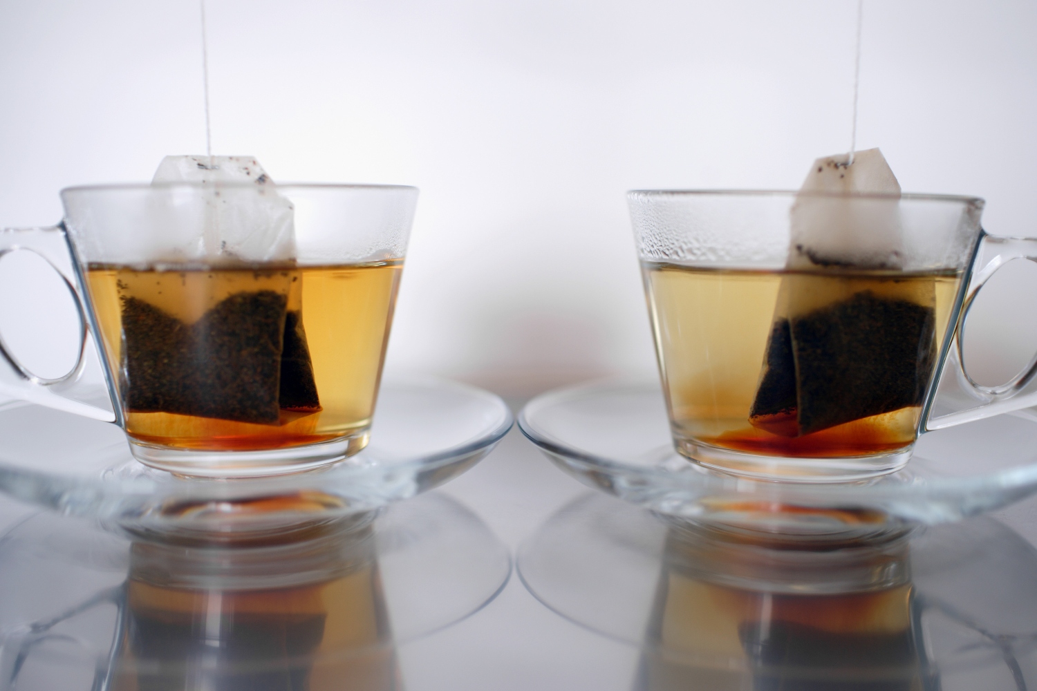 Image shows two tea bags steeping in clear mugs