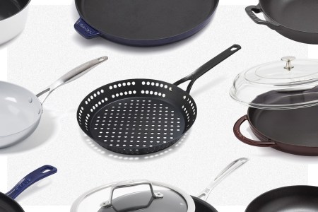 Nine different skillets from Sur La Table's Warehouse Sale on a grey background, including a carbon steel grill skillet, Staub griddle pan and ceramic nonstick skillet