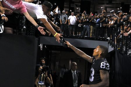 Darren Waller hands a glove to a fan following the team's 33-27 OT victory.