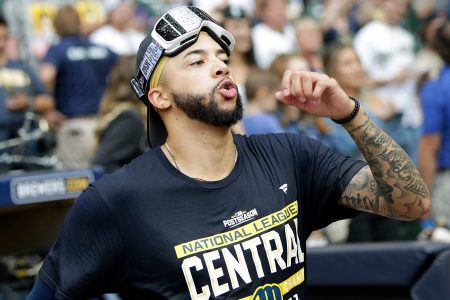 Devin Williams of the Milwaukee Brewers MLB team wearing goggles on his forehead and walking across the field, he had too much to drink while celebrating
