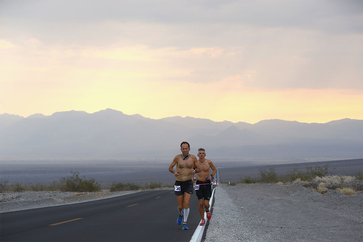 Two men running through the desert.