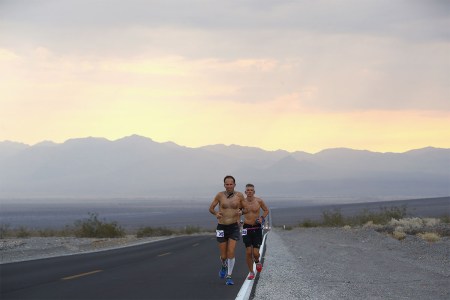 Two men running through the desert.