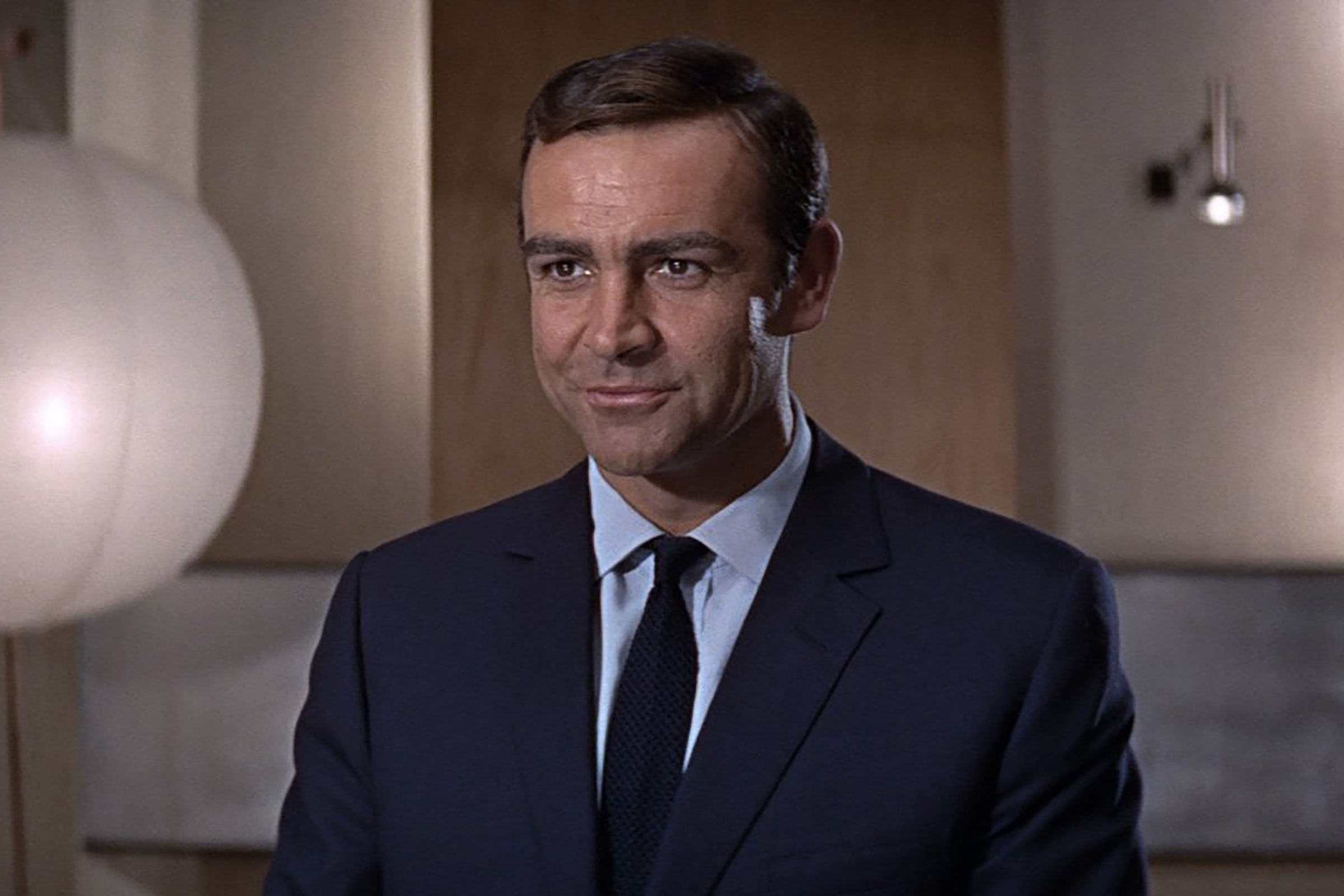 Connery wears a rich flat navy suit with a single button in You Only Live Twice.