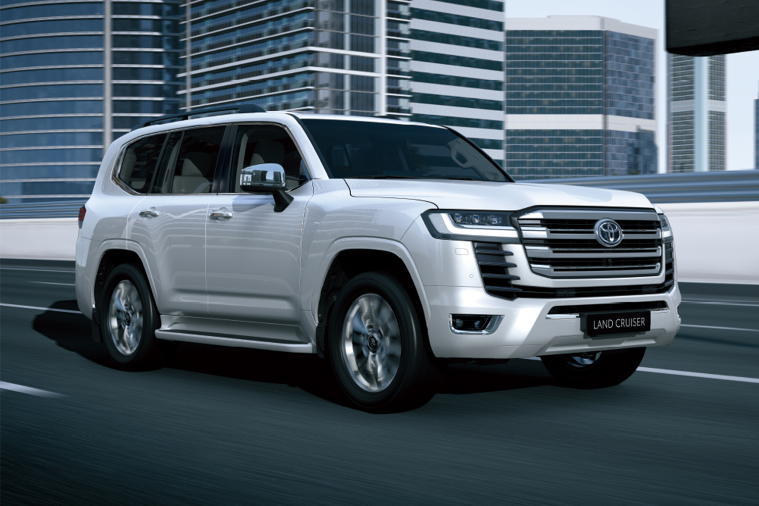 The 2022 Toyota Land Cruiser SUV in white driving down a road in the city