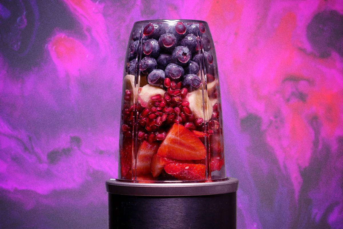Fruit smoothie against a colorful purple background.