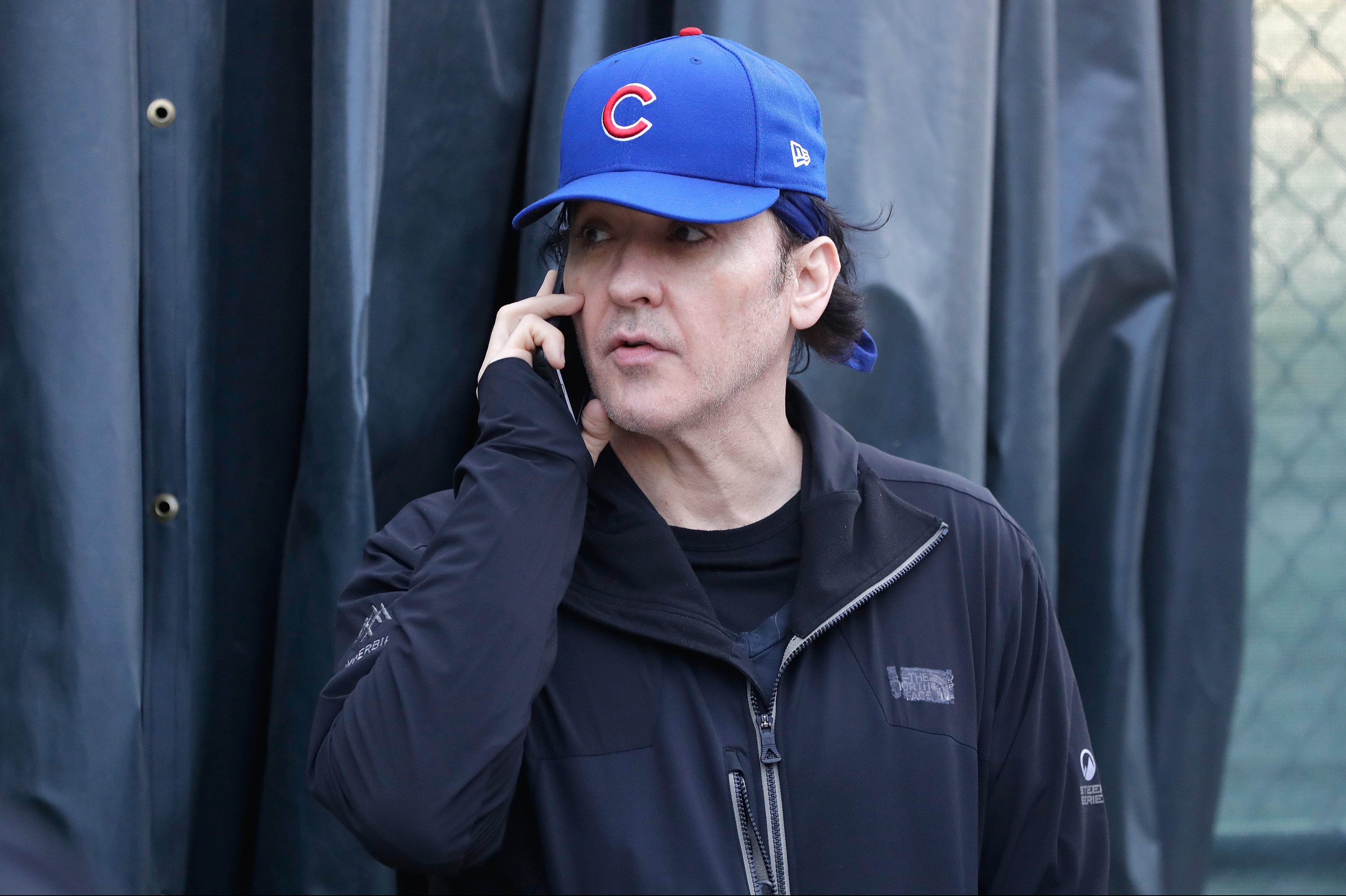 John Cusack stands outside Wrigley Field in Game Three of the 2016 World Series between the Chicago Cubs and the Cleveland Indians at Wrigley Field on October 28, 2016 in Chicago, Illinois. A member of Barstool Sports recently tried to confront the actor about his dual Cubs/White Sox fandom