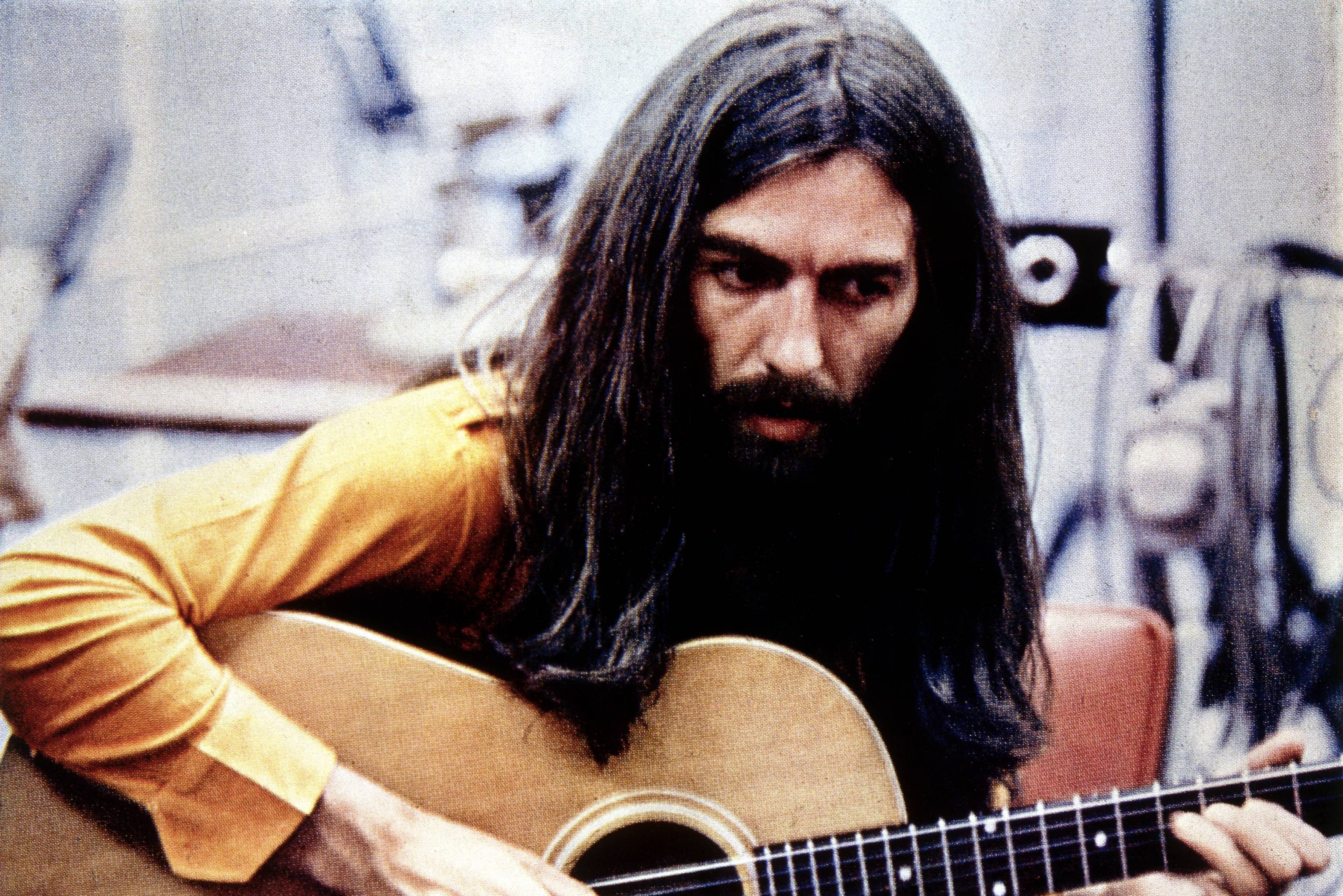 George Harrison playing acoustic guitar circa 1970.