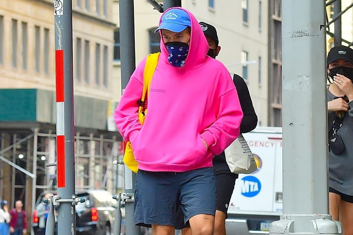 Harry Styles in a pink hoodie and navy shorts