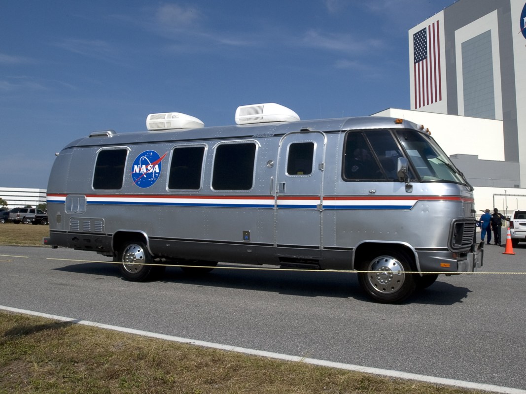 The NASA Astrovan, an Airstream motorhome outfitted to shuttle astronauts to the launch site, sitting still on a road