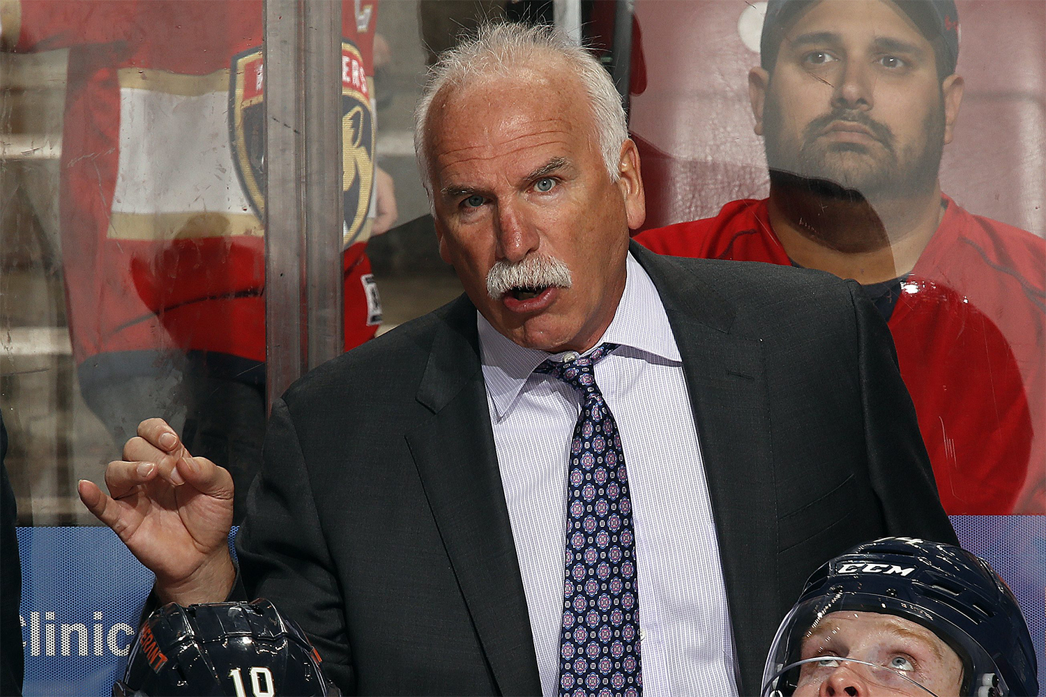 Florida Panthers head coach Joel Quenneville during a game wearing a suit and tie and sporting a white mustache