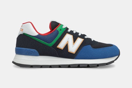 A side shot of the New Balance 574 Rugged Shoe in a black and captain blue colorway. The sneakers are on sale at REI in October 2021.