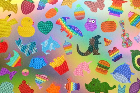 A huge collage of Pop It! fidget toys on a rainbow background.