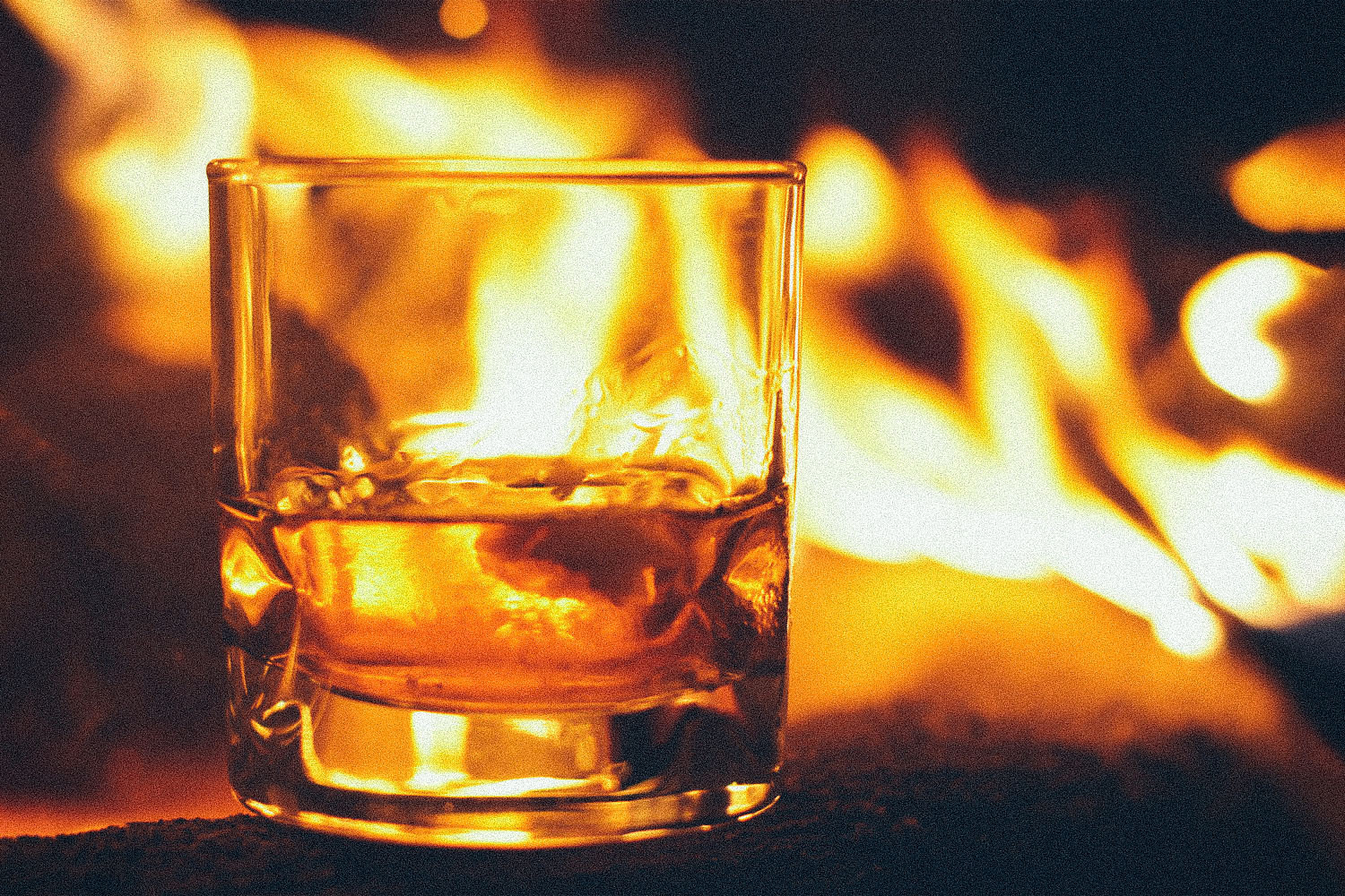 Smoky American whiskeys are a trend; pictured here, a glass of whiskey by a campfre