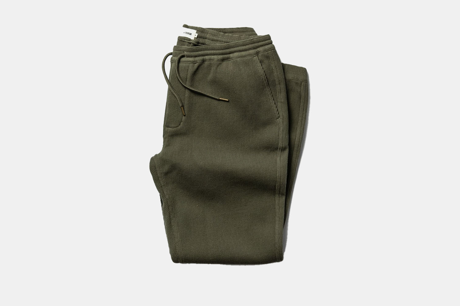 a pair of folded green sweatpants 