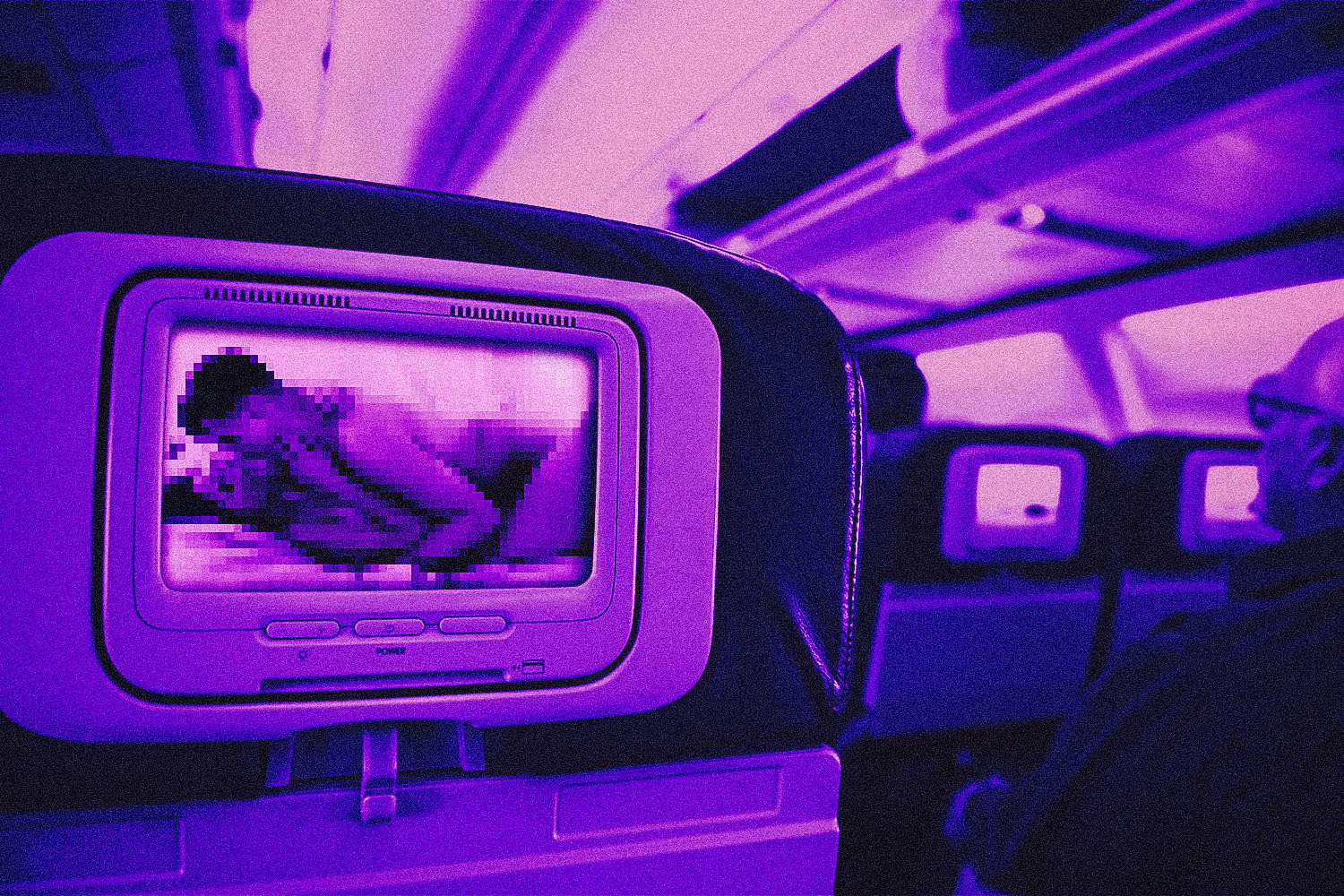 Intimate scene between a man and woman plays on an airplane headrest screen