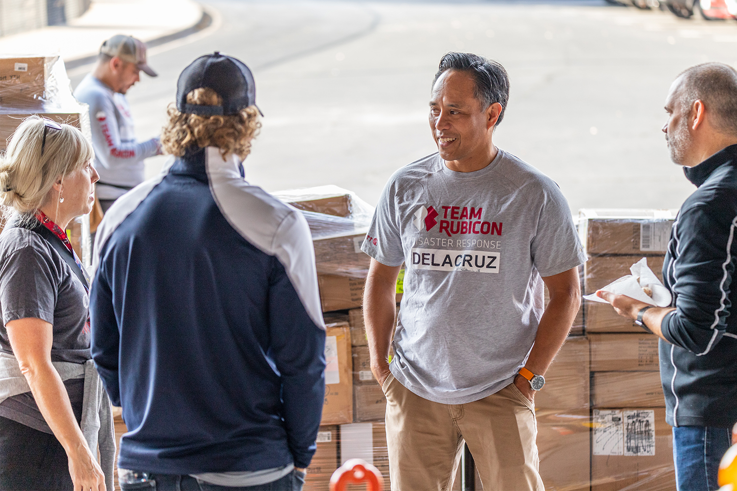 Team Rubicon CEO Art delaCruz in a grey T-shirt (second from right) standing in a group of people at a donation drive for Afghans in Minneapolis, MN on October 9, 2021
