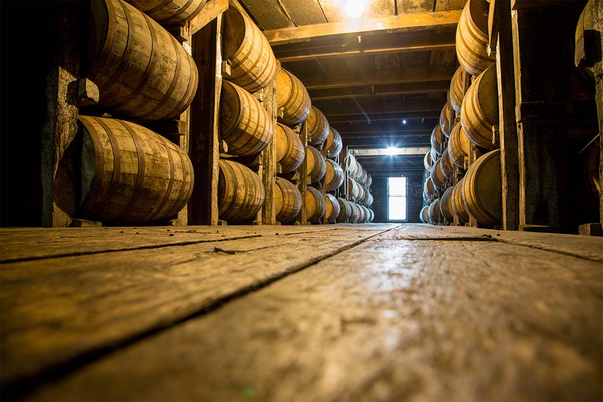Bourbon barrels aging in a warehouse. Kentucky distilleries are getting hit hard by state taxes and international tariffs.