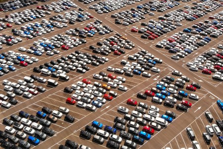 Hundreds of parked cars, trucks and SUVs in a large parking lot during the day