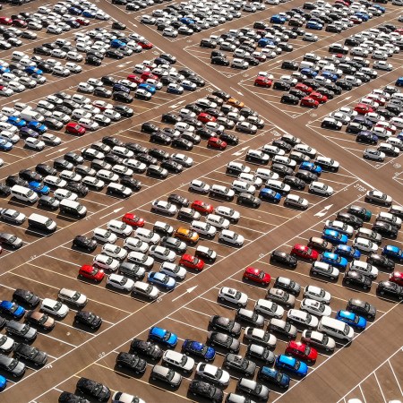 Hundreds of parked cars, trucks and SUVs in a large parking lot during the day