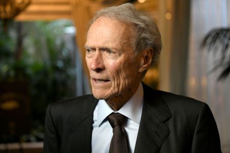 Director Clint Eastwood in a suit and tie looking off to his right