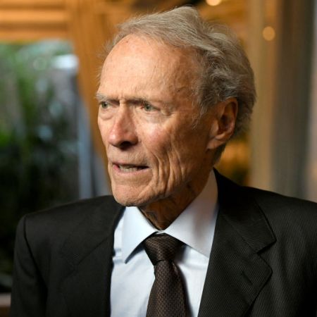 Director Clint Eastwood in a suit and tie looking off to his right