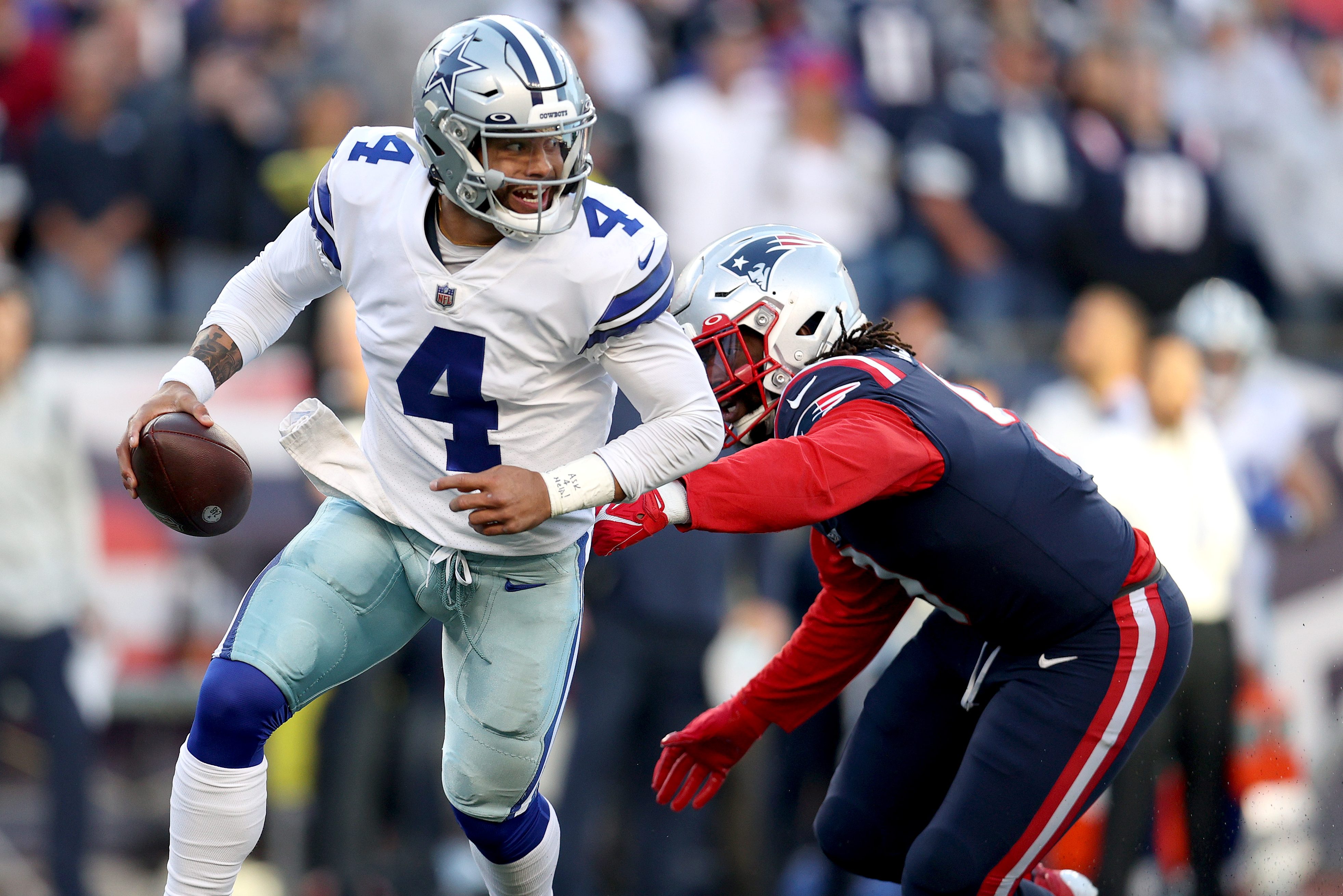 Dak Prescott scrambles with the ball against the New England Patriots