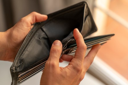 Man's hands opening up empty wallet