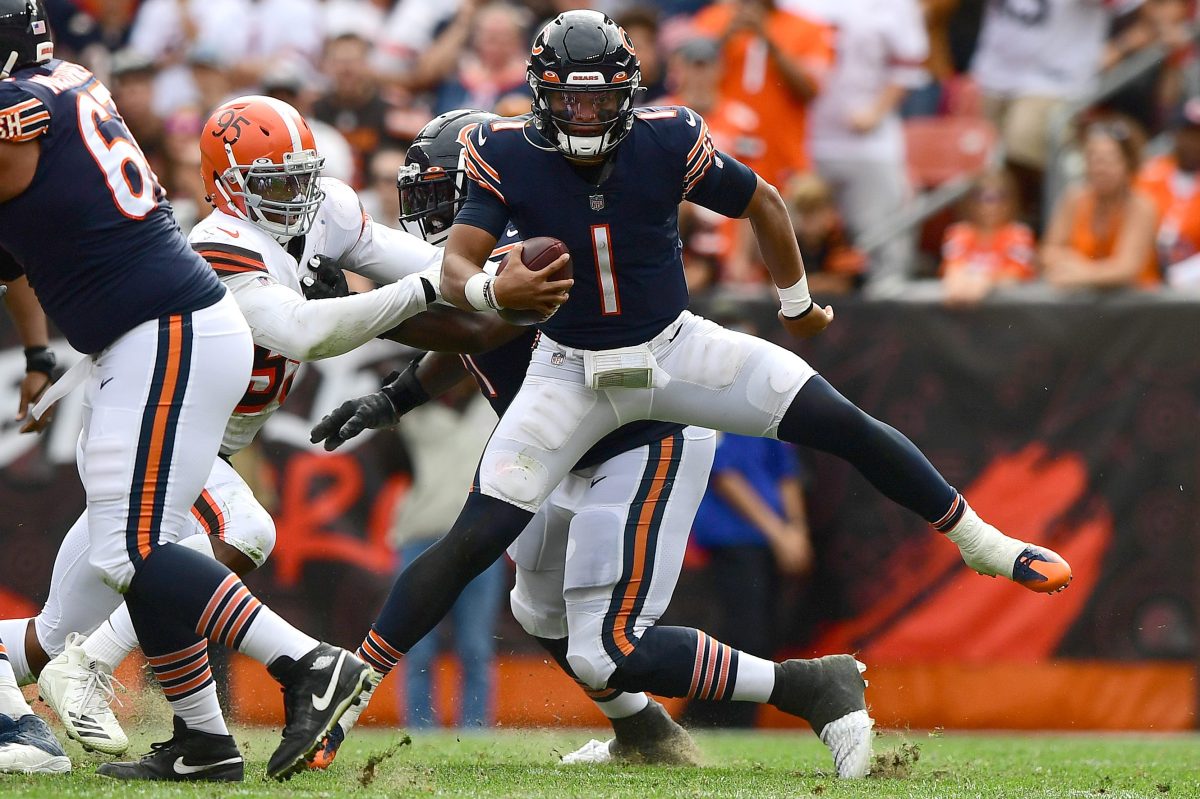 Justin Fields of the Chicago Bears looks to avoid a sack by Myles Garrett