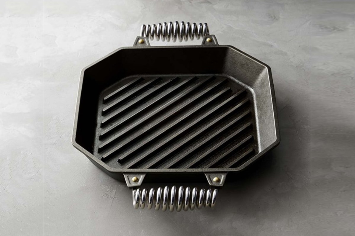 A 12-inch cast iron grill pan from Finex with coiled stainless steel handles on a grey table. It's currently on sale at Williams Sonoma.
