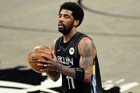 Kyrie Irving of the Brooklyn Nets handles the ball on the court against the Boston Celtics