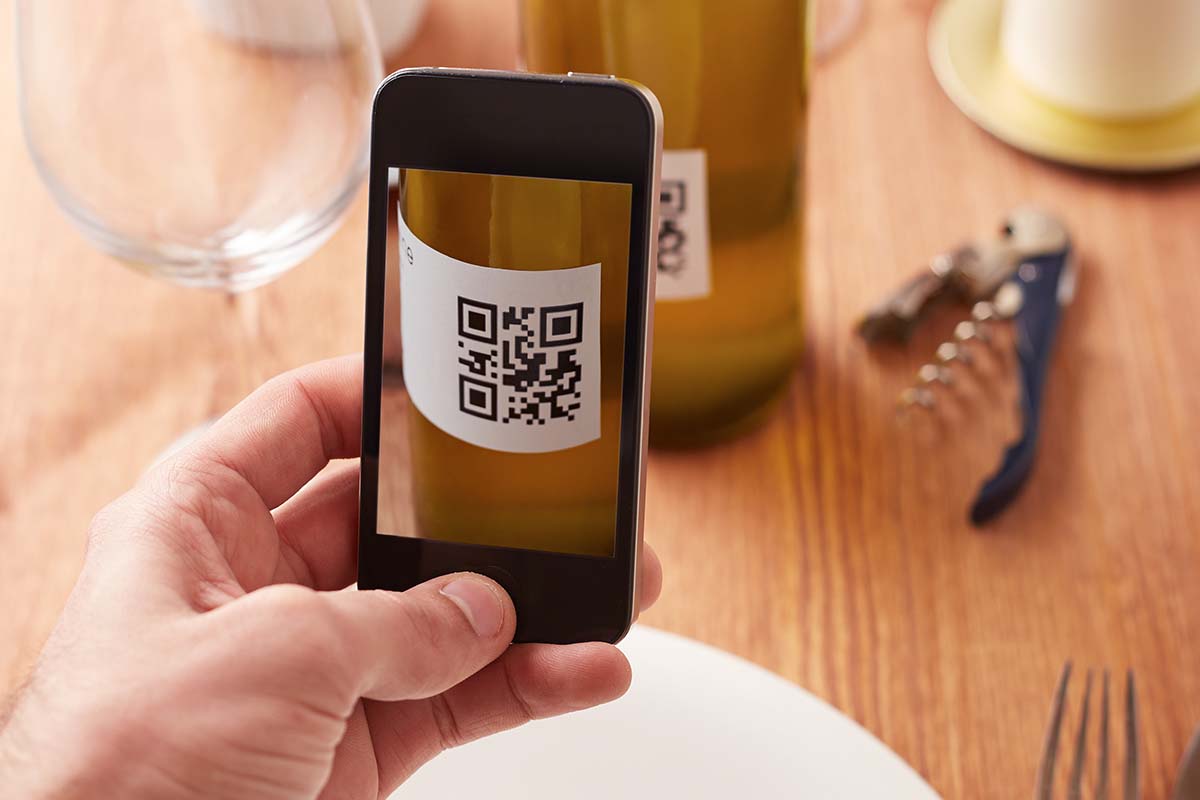 A phone reading a QR label on a bottle of wine. This standard, called U-Label, is coming to bottles in the EU this fall.