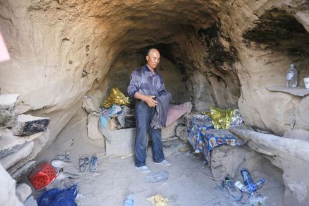 Shepherd Zhu Keming, hailed as a hero in China for rescuing six ultramarathon runners when extreme weather hit the area leaving at least 20 dead, showing the cave dwelling where he sheltered the stricken athletes near the city of Baiyin.