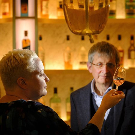Emma Walker succeeds Jim Beveridge OBE becoming the first female Master Blender in the 200-year Johnnie Walker story. Here they are at a bar with Walker swirling Scotch in a glass.