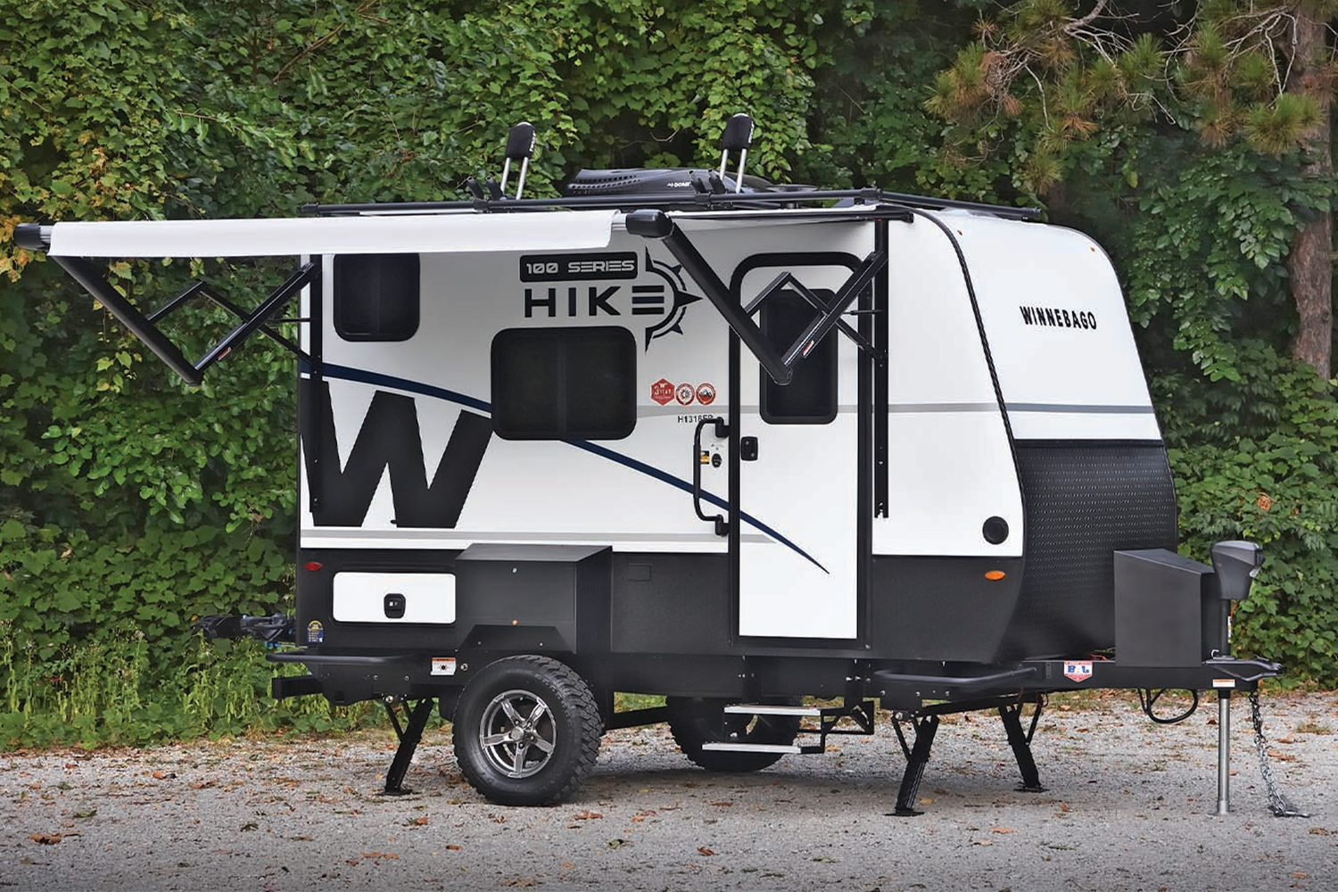 The new Hike 100 travel trailer from Winnebago sitting on a gravel plot in the woods