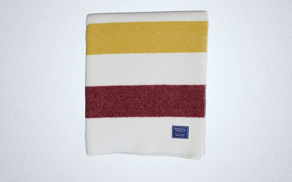 The Faribault Woolen Mill Frontier Wool Blanket in white with colored stripes is soft and warm for winter