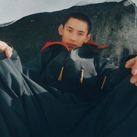 a man sitting in a frozen lace with a collaboration jacket on