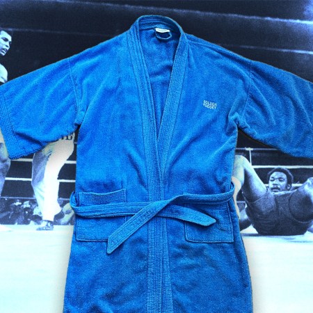 A blue robe given to the writer by Muhammad Ali, atop a scene from one of the boxer's fights