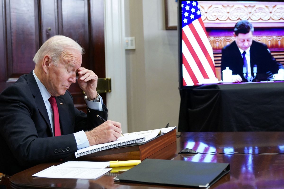 Joe Biden gestures as he meets with China's President Xi Jinping during a virtual summit