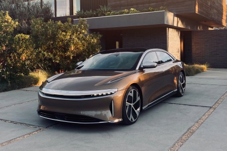 The Lucid Air, a luxury electric sedan from Lucid Motors, sitting in the driveway of a modern house. The EV won MotorTrend's 2022 Car of the Year award.