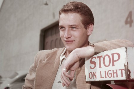 American actor Paul Newman (1925 - 2008) leaning on a sign which reads 'Stop on Light' at a film studio during the filming of 'The Silver Chalice', circa 1954