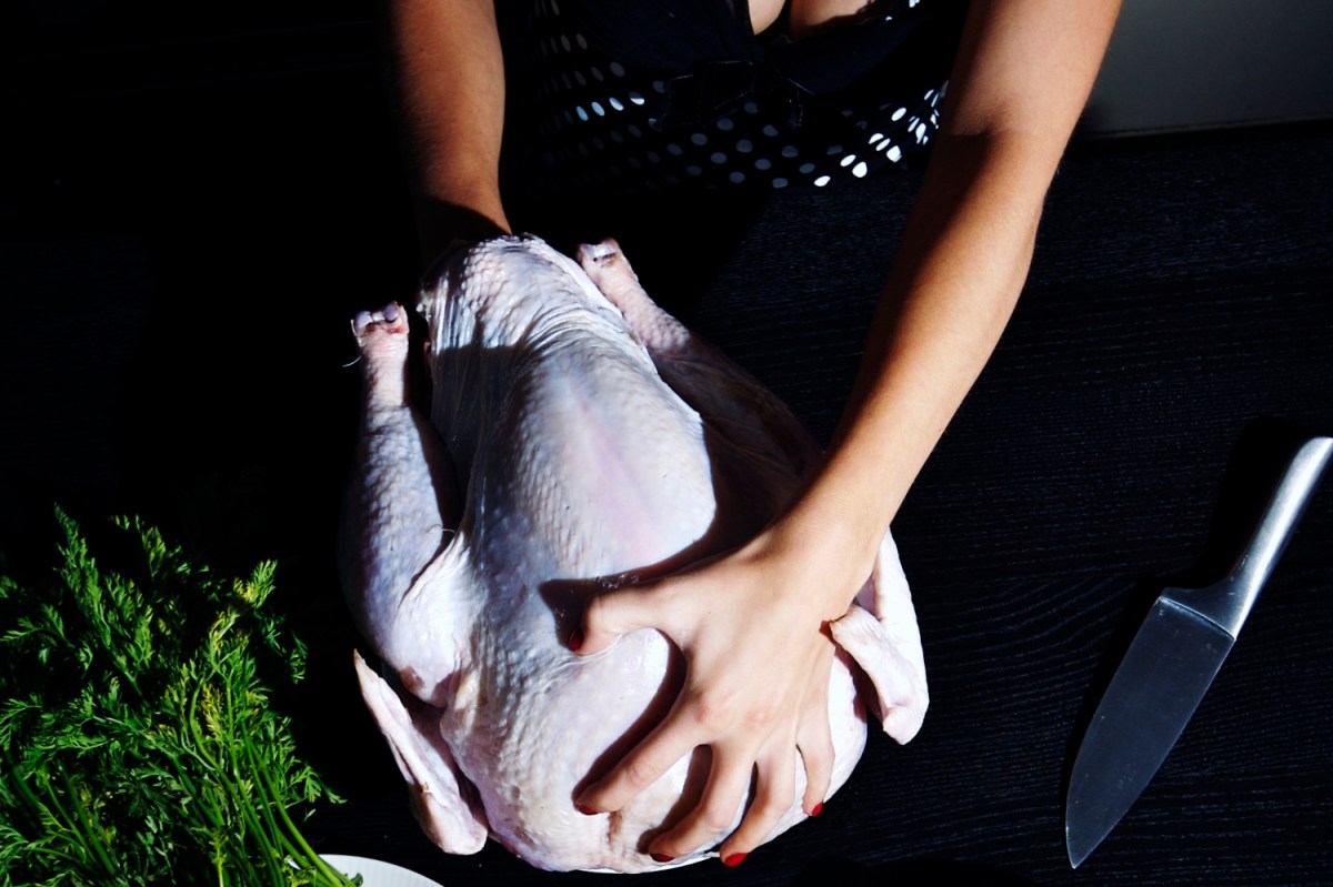 Photograph shows a woman with her hands in a turkey