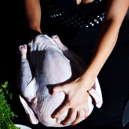 Photograph shows a woman with her hands in a turkey